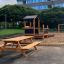 Larchwood Table & Bench in a playground near sandbox and play structure.